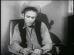 B/W 1955 James Dean in cowboy hat looking down + talking to someone off screen / PSA Stock Footage