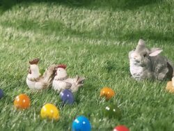 Bunnies, chicks and colored eggs laying on the green grass Stock Footage