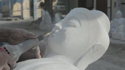 CU A stonemason carves a marble Buddha statue in Mandalay's stone carving district / Mandalay, Myanmar Stock Footage