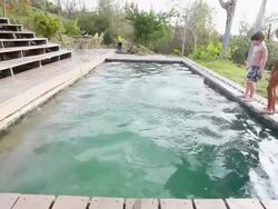 MS Shot of little girl does back dive into pool, little boy does front flip into pool and another little girl does cartwheel into pool / Montezuma, Punteranes, Costa Rica Stock Footage