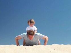 Personal trainer  - father and son do press ups on the beach Stock Footage