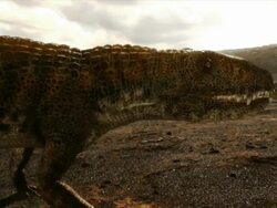 Medium Long Shot pan-right - A creature in a mountainous desert captures and eats prey in a computer-generated animation. / New York City, New York, USA Stock Footage