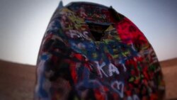 Graffiti painted Cadillac sticks out of the ground at Cadillac Ranch with sun flare Stock Footage