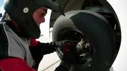 Pit-crewman tightens new race-car tire lug-nuts Stock Footage