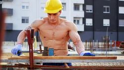 Blue collar worker on construction site, banding armature Stock Footage