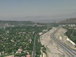 January 1, 2010 AERIAL Suburbs and surrounding mountains, River Mapocho, the Costanera Norte highway, and airfield with gliders / Santiago de Chile, Gran Santiago, Chile Stock Footage