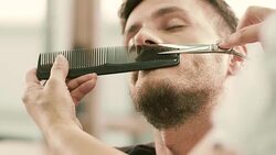 Barber cut a client's mustache with clippers Stock Footage