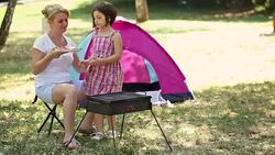 Young Mother And Daughter Grilling Meat On Barbecue Stock Footage