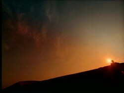 low angle CANTED silhouette man running towards camera down hill at sunset Stock Footage