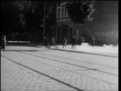 B/W 1961 PAN man picking up smoke bomb + throwing it back over Berlin Wall / Germany Stock Footage