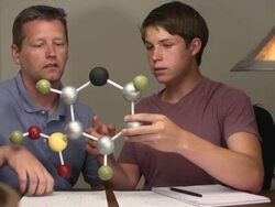 Son Shows Father his Science Project of a Molecule Stock Footage