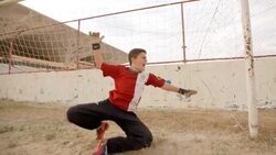 Young goalkeeper dives but misses and falls in the dust in defeat Stock Footage