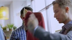 Young man admires shirt in clothing shop, store manager offers advice and assistance and closes the deal Stock Footage