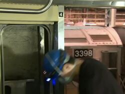 An MTA employee uses a screwdriver to remove a door from a train car. Stock Footage
