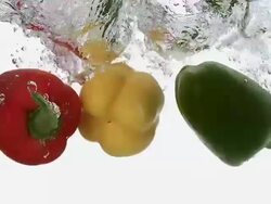 MS SLO MO Red, yellow and green capsicum falling into water against white background / Vieux Pont, Normandy, France  Stock Footage