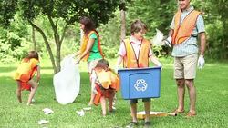 Volunteers: Family cleans up their community park. Recycling bin. Stock Footage