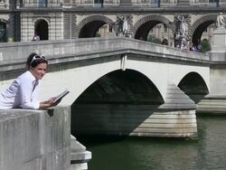 MS Woman standing on bridge and reading book near river / Paris, Ile-de-France, France    Stock Footage