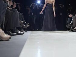 MS LA Model in gown walking down catwalk during fashion show photographers in background Stock Footage