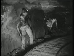 Miners work with picks and shovels to extract coal from a mine. News Clip