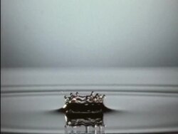 High Speed CU water drops splashing into pool of water, one after the other, silver background, side view Stock Footage