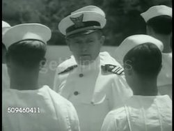 1938: US COAST GUARD: Officer in white uniform inspecting men in sailor uniforms standing in lines, formation. Officer explaining rope to sailors. Coast Guard insignia (Shield of Freedom) on uniform sleeve. CG Sailors in uniform (same as US Navy) Instructional Video