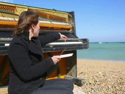 thoughtful young woman writing at the piano Stock Footage