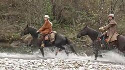 SLO MO TS Three horseback riders crossing river on horses Stock Footage