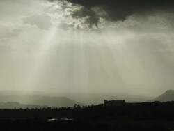 Dramatic dark clouds, broken by sunlight move across a moody and sombre Moroccan landscape. Stock Footage