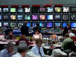 ARCHIVAL Time lapse - MCU People working in Television News Room, banks of TV screens in background Stock Footage