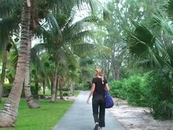 Blond woman walking on a tropical garden Stock Footage