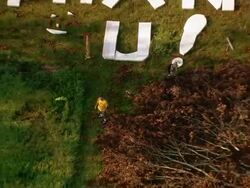 Sept. 11, 2005 aerial man giving thumbs-up by Thank You written in grass after hurricane / Louisiana Stock Footage