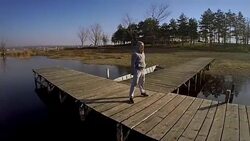 Young man doing squats outdoors Stock Footage