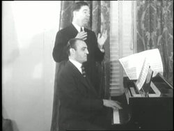 U.S. Senator Huey Long holds his original composition, Every Man A King, for composer Harry Link to play. News Clip