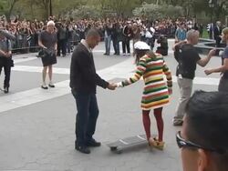Mark Salling (L) teaches Lea Michele the fine art of skateboarding while on the set of the season finale of 'Glee' in Washington Square Park in Greenwich Village in New York 04/29/11 (Footage by WireImage Video/GettyImages) Stock Footage