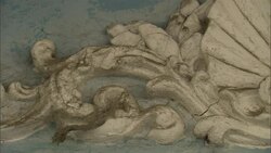 Dried flotsam hangs from a cracked decorative sculpture on a flood-damaged structure. Stock Footage