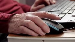 Elderly woman using a computer mouse Stock Footage