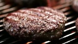 SLO MO LD of beef burger sizzling on a grill Stock Footage