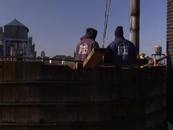 Construction workers build a water storage tower high above a New York City neighborhood. Stock Footage