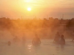 hot spring at sunrise, people swimming Stock Footage