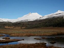 WS View of Wind makes ripples on small lagoon in front of snow covered mountain / Iceland  Stock Footage