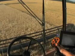 MS POV Combine harvester automatically controlling harvester's steering with farmer monitoring machine operation while harvesting winter wheat / Dansville, Michigan, United States Stock Footage