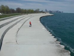 Elevated view of inline skater traveling on a walkway by the Lake Michigan shoreline. Stock Footage