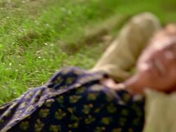 Selective focus medium shot pan middle aged woman lying on grass laughing / Nova Scotia, Canada Stock Footage
