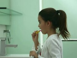 MS Young girl brushing teeth looking in bathroom mirror Stock Footage