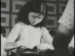 1936: SHANGHAI, CHINA: Women in gloves at long table sorting product, possibly tea. TEA HOUSE/RESTAURANT: Elder male drinking tea fanning self, younger male drinking from cup, NODDING. Instructional Video