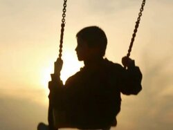 boy on a swing at sunset Stock Footage