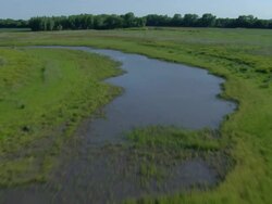 Following a river tributary with green grass surrounding it Stock Footage