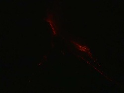 Red hot glowing boulders of lava roll down side of erupting volcano at night, Philippines, Dec 2009 Stock Footage