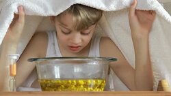 boy under towel breathes balsam vapors to treat colds Stock Footage