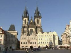 Wide Shot static-Pedestrians pass through a beautiful town square in Prague. / Prague, Czech Republic Stock Footage